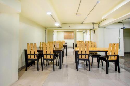 a dining room with wooden tables and chairs at OYO 928 Leaf Hostel in Chiang Mai