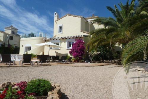 ein großes weißes Haus mit einer Palme davor in der Unterkunft Las Brisas 87 in Atamaría