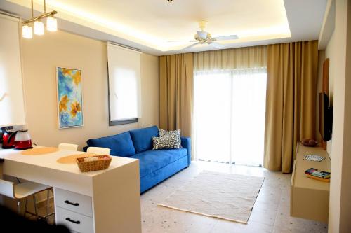 a living room with a blue couch and a table at Mozaik Hotel in Oludeniz