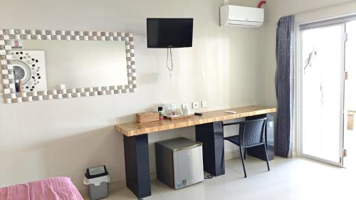 a room with a desk with a mirror and a window at Silver Fern Beach Retreat in Sekotong