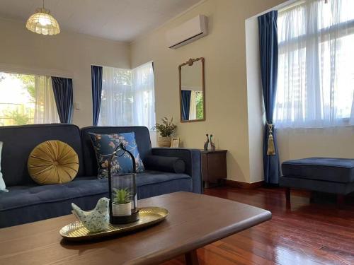 a living room with a blue couch and a table at S&N classic 3 bedrooms house opposite Waikato Hospital in Hamilton