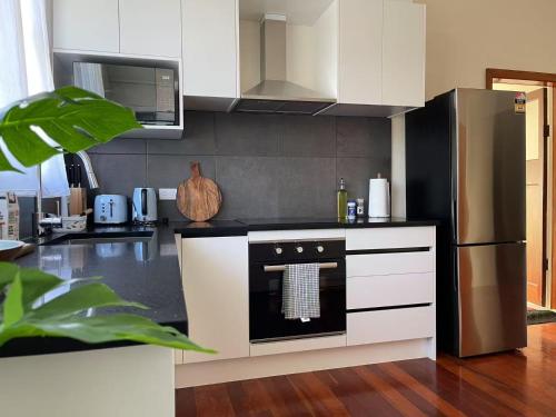 a kitchen with a stove and a refrigerator at S&N classic 3 bedrooms house opposite Waikato Hospital in Hamilton