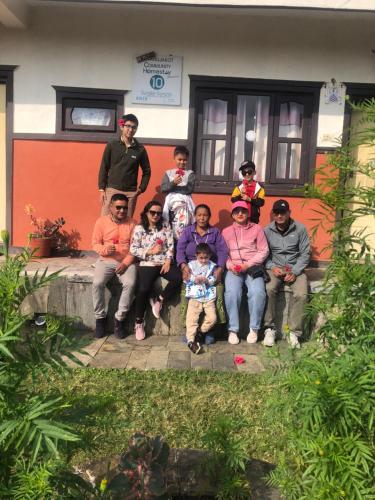 a group of people sitting in front of a house at Anne Homestay in Astam