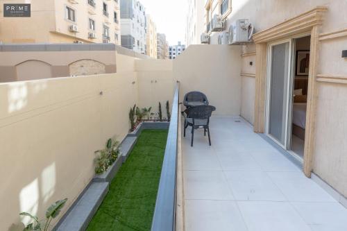 a small balcony with grass on the side of a building at Prime Residence Zayed Heights in Sheikh Zayed