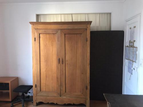 a wooden cabinet in the corner of a room at Chambre chez l'habitant dans un appartement à 2 pas de la gare SNCF et à 300m de la gare routière in Creil