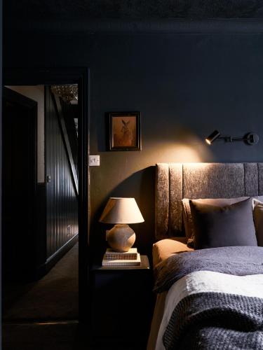 a bedroom with a bed and a lamp on a table at Cambridge House in Windermere