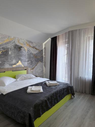 a bedroom with a bed with two towels on it at Vila Popasul Dacilor in Grădiştea de Munte