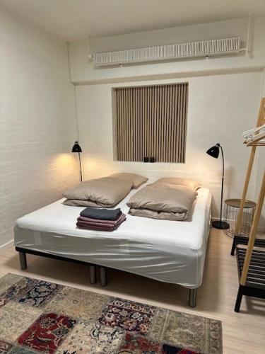 a bedroom with a bed with two pillows on it at Struer Festcenter - Vest Bowl lejlighed 2 Bredgade 62 A in Struer