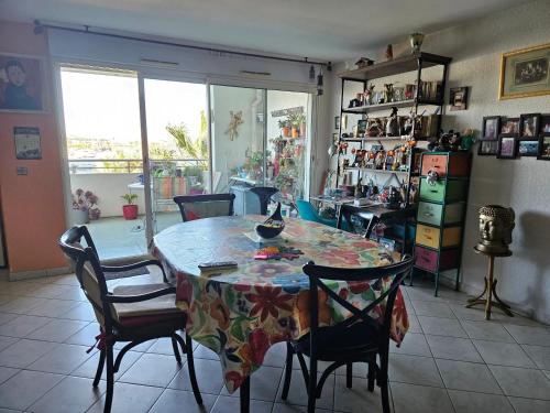 une salle à manger avec une table et des chaises ainsi qu'une chambre avec une fenêtre dans l'établissement Appartement spacieux avec vue sur la mer à Sète, à Sète