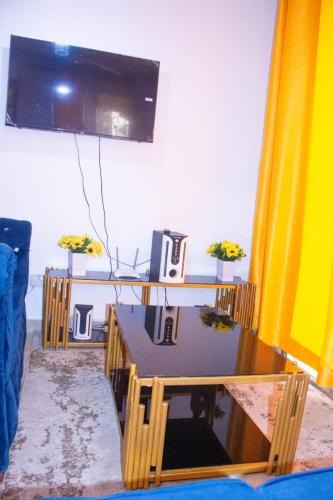 a living room with a table and a television at Bamburi Luxury Homes II One bedroom apartment in Bamburi