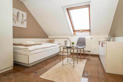 a small attic bedroom with a bed and a table at Ruby restoran & prenoćište in Nova Gradiška