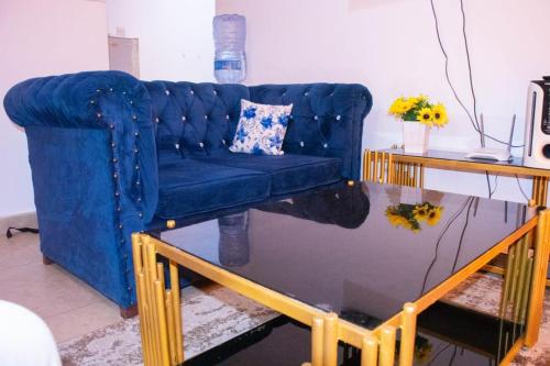 a blue couch in a living room with a table at Bamburi Luxury Homes II One bedroom apartment in Bamburi