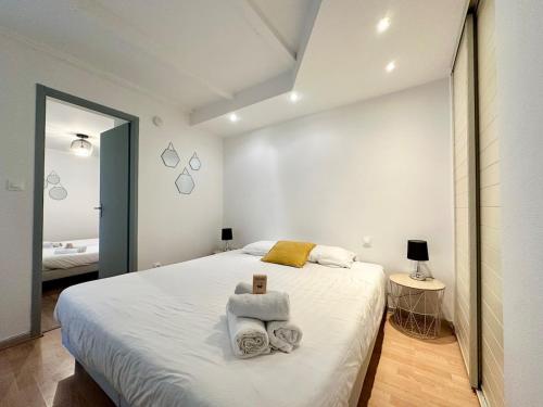 une chambre avec un grand lit avec des serviettes dessus dans l'établissement La Tannière - 4 à 6 personnes - Lit KingSize - Proche Gare, à Nancy