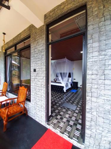 a room with a large window with a bed and a table at Ella Happy View Homestay in Ella