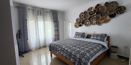 a bedroom with a bed with plates on the wall at Private cosy home close to city center with views in Kigali