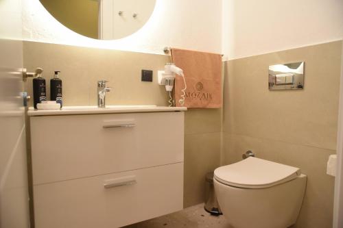 a bathroom with a toilet and a sink and a mirror at Mozaik Hotel in Oludeniz