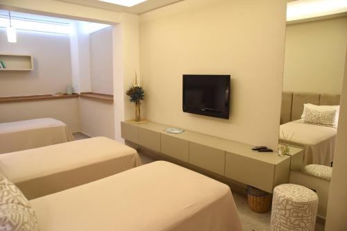 a hotel room with two beds and a tv at Mozaik Hotel in Oludeniz