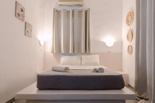 a bedroom with a bed with two towels on it at Seven Grapes - Karterados in Karterados