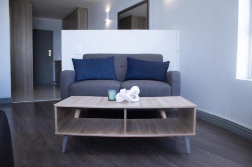 a living room with a couch and a coffee table at Ocean Breeze Hotel in Strand