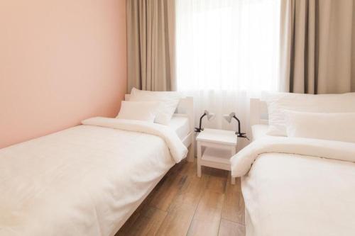 two white beds in a room with a window at Golf Čertovo břemeno in Jistebnice