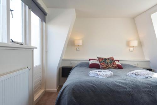a bedroom with a bed with two pillows on it at Garden House Harry in Zandvoort
