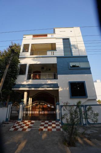Bhakti Bliss Homestay - Spacious 2bhk AC Apartment near Padmavati Ammavari Temple in Tirupati في تيروباتي: مبنى ابيض امامه بوابة