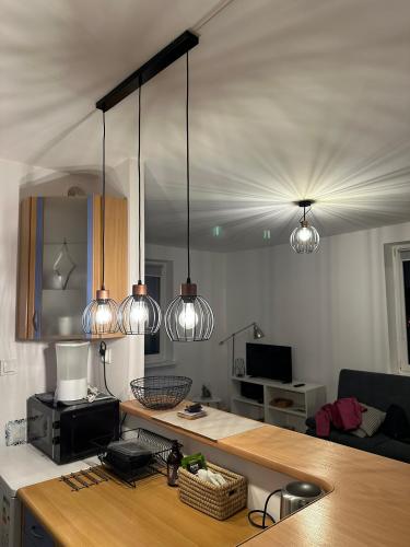 a kitchen with three lights hanging from the ceiling at Panorama Bałtyku in Sopot