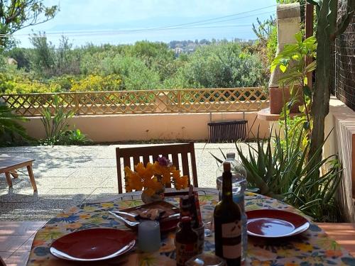 卡皮塔纳Tuffo nel blu Capitana, Best Vacation Ever的露台上的一张桌子,上面放有盘子和瓶装葡萄酒