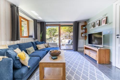 un salon avec un canapé bleu et une télévision dans l'établissement Spacieux 6pax 3ch Vue MtBlanc Central Parking, à Chamonix-Mont-Blanc