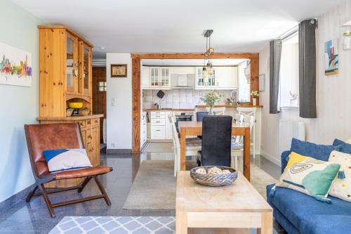 un salon avec un canapé bleu et une cuisine dans l'établissement Spacieux 6pax 3ch Vue MtBlanc Central Parking, à Chamonix-Mont-Blanc