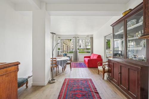 un salon avec un canapé rouge et une table dans l'établissement Branly - Franco Russe 1bdr B'Your Home, à Paris