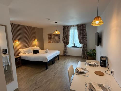 une chambre d'hôtel avec un lit, une table et des chaises dans l'établissement Appart hotel Marseille Aéroport, à Vitrolles