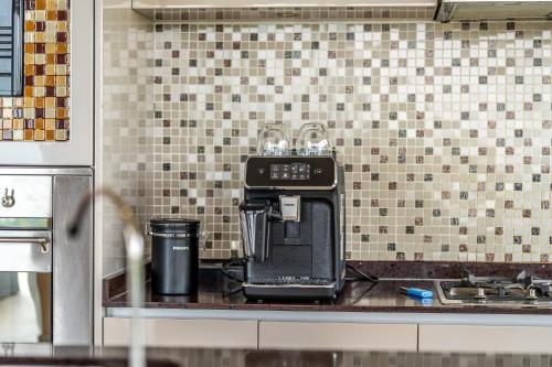 a coffee maker on a counter in a kitchen at White Monkey Villa - Private Pool & Jacuzzi in Pantai Cenang
