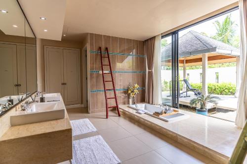 a bathroom with two sinks and a ladder at White Monkey Villa - Private Pool & Jacuzzi in Pantai Cenang