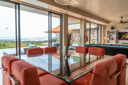 a living room with a pool table and chairs at White Monkey Villa - Private Pool & Jacuzzi in Pantai Cenang