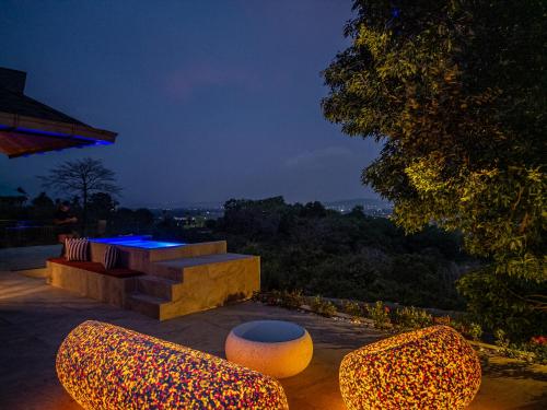 a patio with two chairs and a bench at night at White Monkey Villa - Private Pool & Jacuzzi in Pantai Cenang