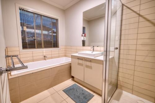 a bathroom with a tub and a sink and a shower at Warm and romantic cottage-4Bed-9guests in Tarneit