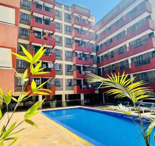 a building with a swimming pool in front of a building at Epic brownstone Apartments Phase 1 in Nairobi