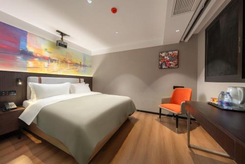 a bedroom with a large bed and a desk and a chair at NOX Hotel in Chengdu