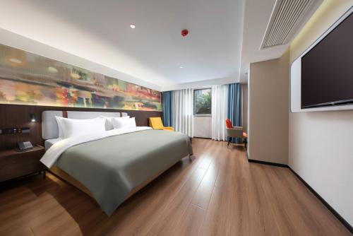 a hotel room with a bed and a flat screen tv at NOX Hotel in Chengdu