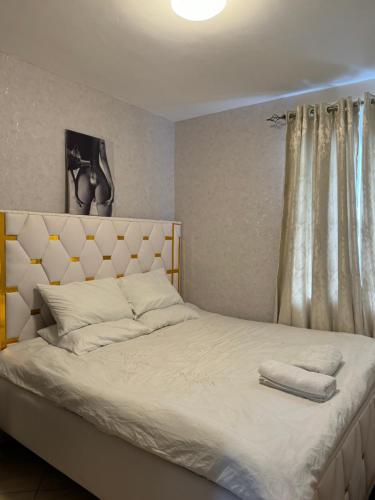 a bedroom with a large bed with white sheets at Epic brownstone Apartments Phase 1 in Nairobi