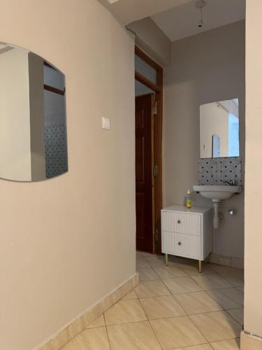 a bathroom with a sink and a mirror on the wall at Epic brownstone Apartments Phase 1 in Nairobi