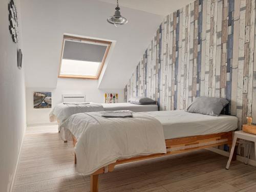 une chambre avec deux lits et une fenêtre dans l'établissement Duplex Normandie, tout confort Saint Valery en Caux, à Saint-Valery-en-Caux