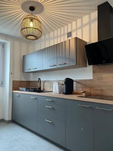 une cuisine avec des armoires en acier inoxydable et un plafond dans l'établissement La Fortification - Séjour à Auxerre, à Auxerre