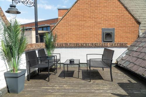 a patio with chairs and a table and a building at The Red Lion Hotel in Spalding