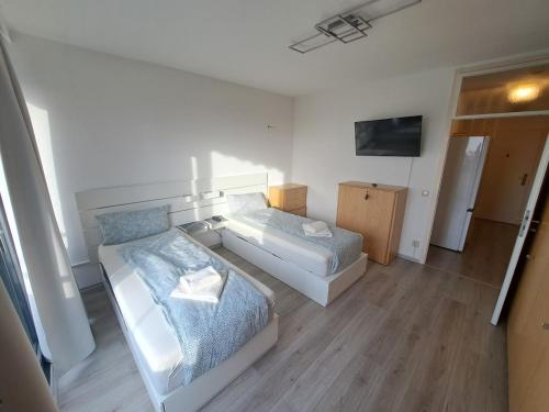 ミュルハイム・アン・デア・ルールにあるApartment with Balcony in Mülheim an der Ruhrのベッドが2つとテレビがある部屋