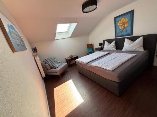 a bedroom with a large bed and a window at Ferienwohnung Baumgartner Chiemseeliebe 2OG in Breitbrunn am Chiemsee