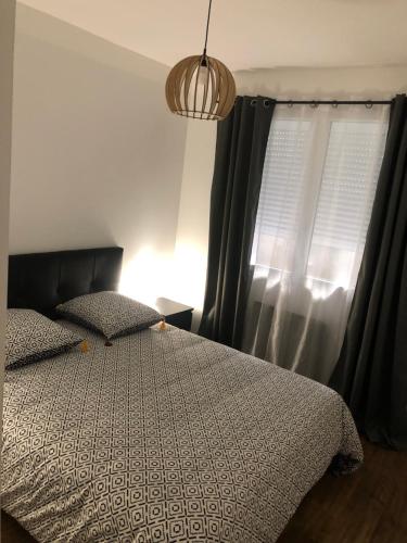 a bedroom with a bed and a window with curtains at APPARTEMENT F3 BOX Vélo Moto Centre historique in Mirepoix
