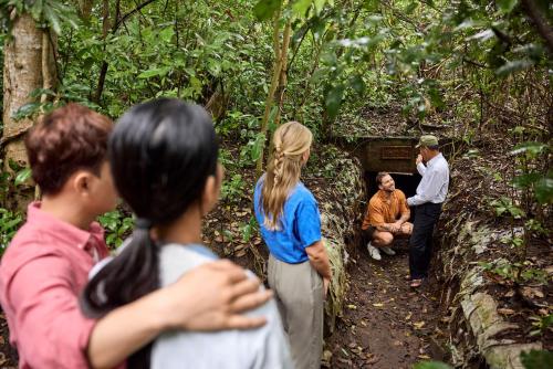 a group of people looking at a man standing in a tunnel at ROBINSON Nam Hoi An in Tam Ky