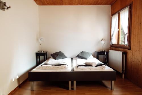 a bedroom with a bed and two windows at La Pierre à Catillon in Moleson
